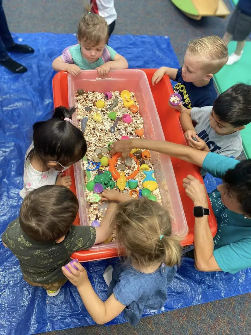 A bunch of kids playing with legos inside a box